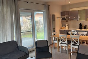Una cocina moderna con comedor, ventanas amplias y puertas correderas a un patio.