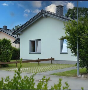 A light-colored house with a gabled roof, a chimney, and a window. - Vacation Home "Sandbank" in Zierow on the Baltic Sea (Zierow)