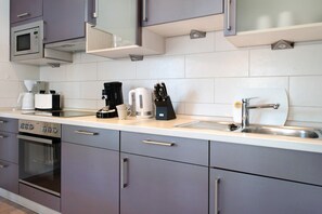 Eine moderne Küche mit Edelstahlgeräten, einem Backofen und einem Spülbecken.