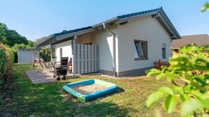 Une maison de plain-pied avec un patio couvert, une petite piscine et une cour clôturée.