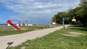 Un parc doté d’une aire de jeux, d’un terrain de basketball et d’un sentier menant à un plan d’eau.