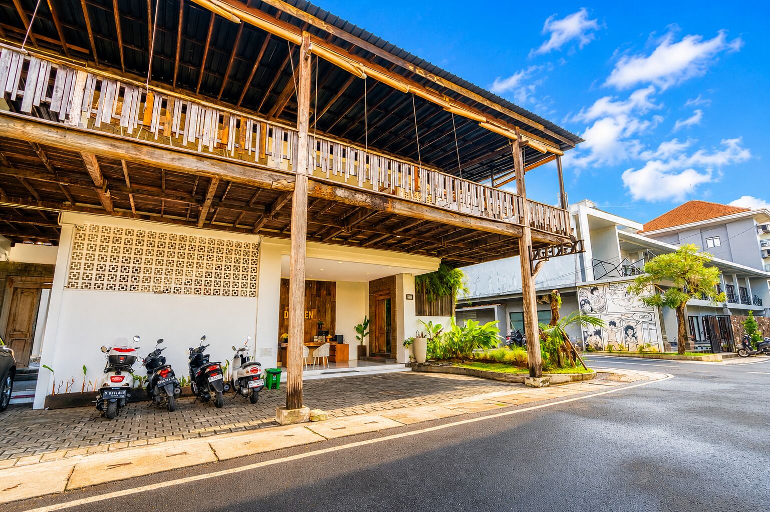 A building with a wooden structure, a covered entrance, and a row of parked motorcycles.