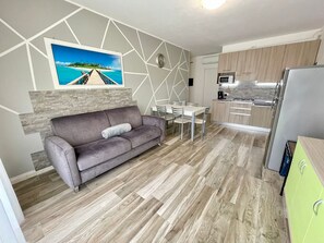 A modern kitchen with a microwave, stove, and green cabinets. - Vibrant stay with shared outdoor pool (Città Metropolitana di Venezia)