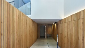 A modern interior with wooden panel walls, a glass door, and a concrete floor. - Fontana | The Rentals Collection (San Sebastián)