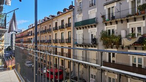 A multi-story residential building with balconies, a pedestrian walkway, and parked cars. - Fontana | The Rentals Collection (San Sebastián)