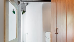 A hallway with wooden flooring, a white wardrobe, and a mirror with green lighting. - Casa Centotrecento by Wonderful Italy (Bologna)