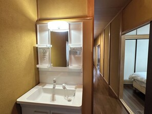 A bathroom with a sink, mirror, and towel rack. - Vrbo Property (台東区)