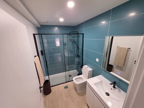 A modern bathroom with a glass-enclosed shower, a toilet, and a sink. - Quarto Suite Fish QM (Coimbra)