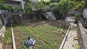 A courtyard with a paved walkway, a lamp post, and a small garden area with plants. - Quarto Suite Hope Vista Jardim (Coimbra)
