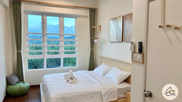 Une chambre avec une grande fenêtre, un lit, une table de chevet, une lampe et une porte.