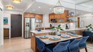 Una cocina moderna con armarios de madera, un refrigerador de acero inoxidable y una isla central con pileta.
