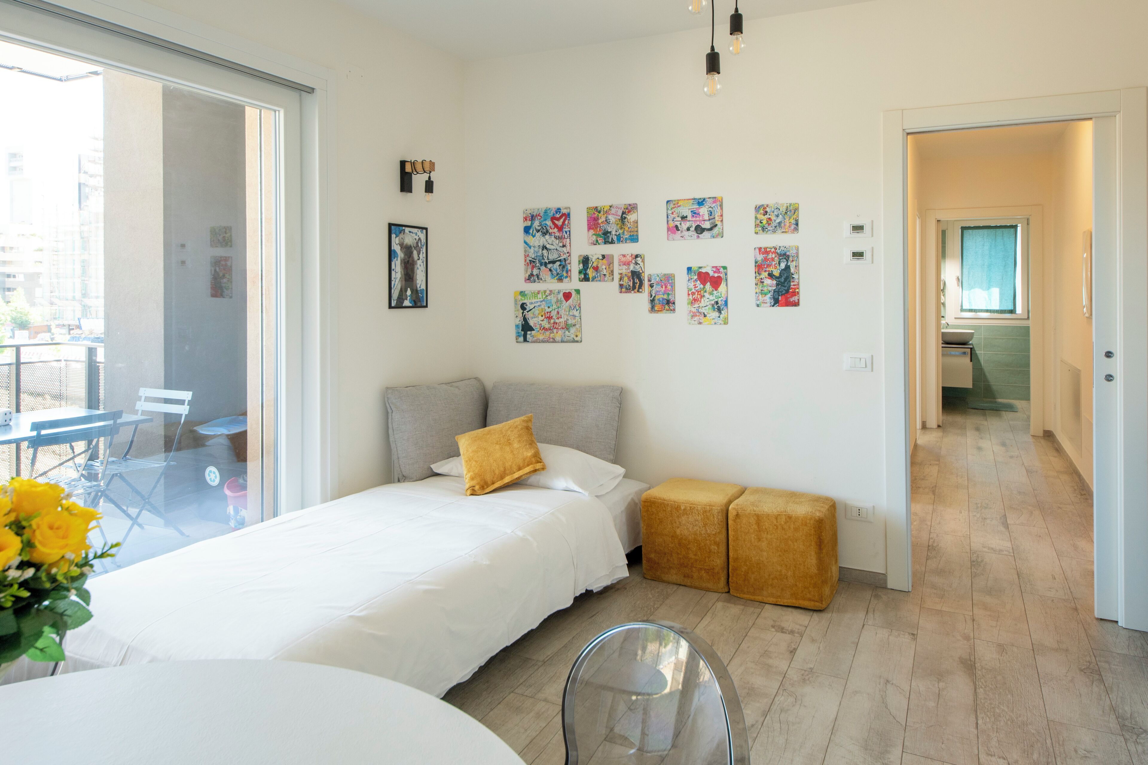 Un dormitorio moderno con una cama, una mesita de cristal y un sofá.