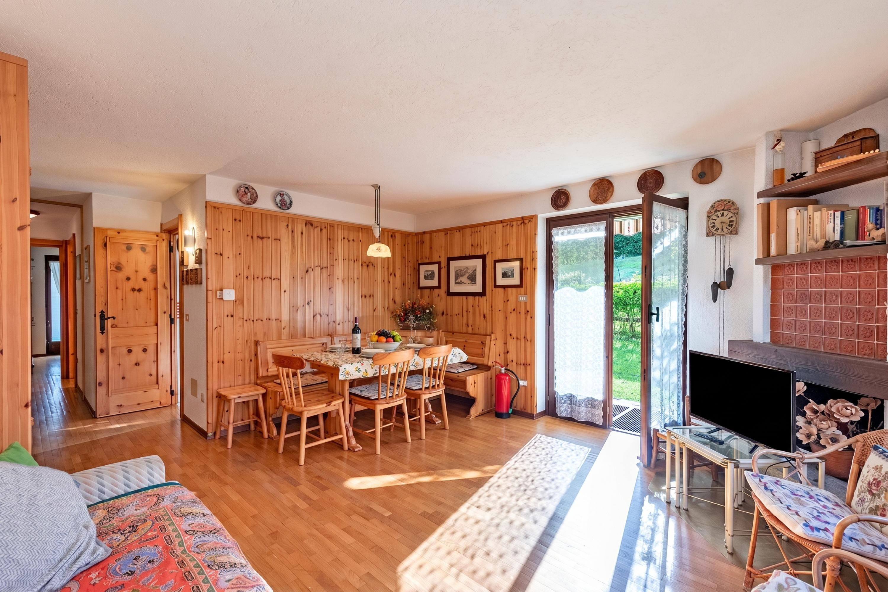 Un intérieur en bois comprenant un coin repas, un téléviseur et une cheminée.