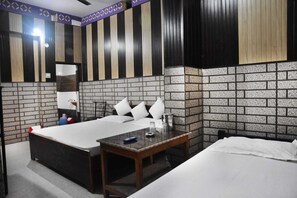 Et hotelværelse med seng, natbord og et lille skrivebord.
