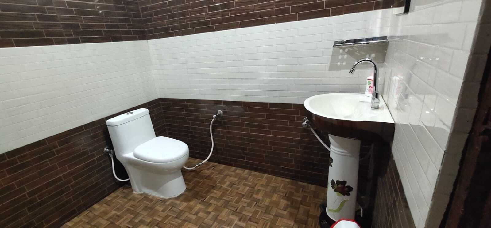 A bathroom with a toilet, a sink, and a shower area.