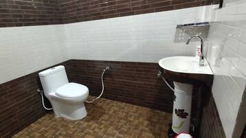 A bathroom with a toilet, a sink, and a shower area.