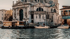 A historic building with a large dome and a bell tower, situated by a body of water. - Cozy apartment near the station (Venezia)