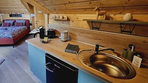 Ett litet kök med en diskho, en kaffebryggare och en brödrost.