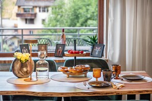 Ein Esstisch mit Tellern, Besteck, einer Blumenvase und einer Wasserflasche.