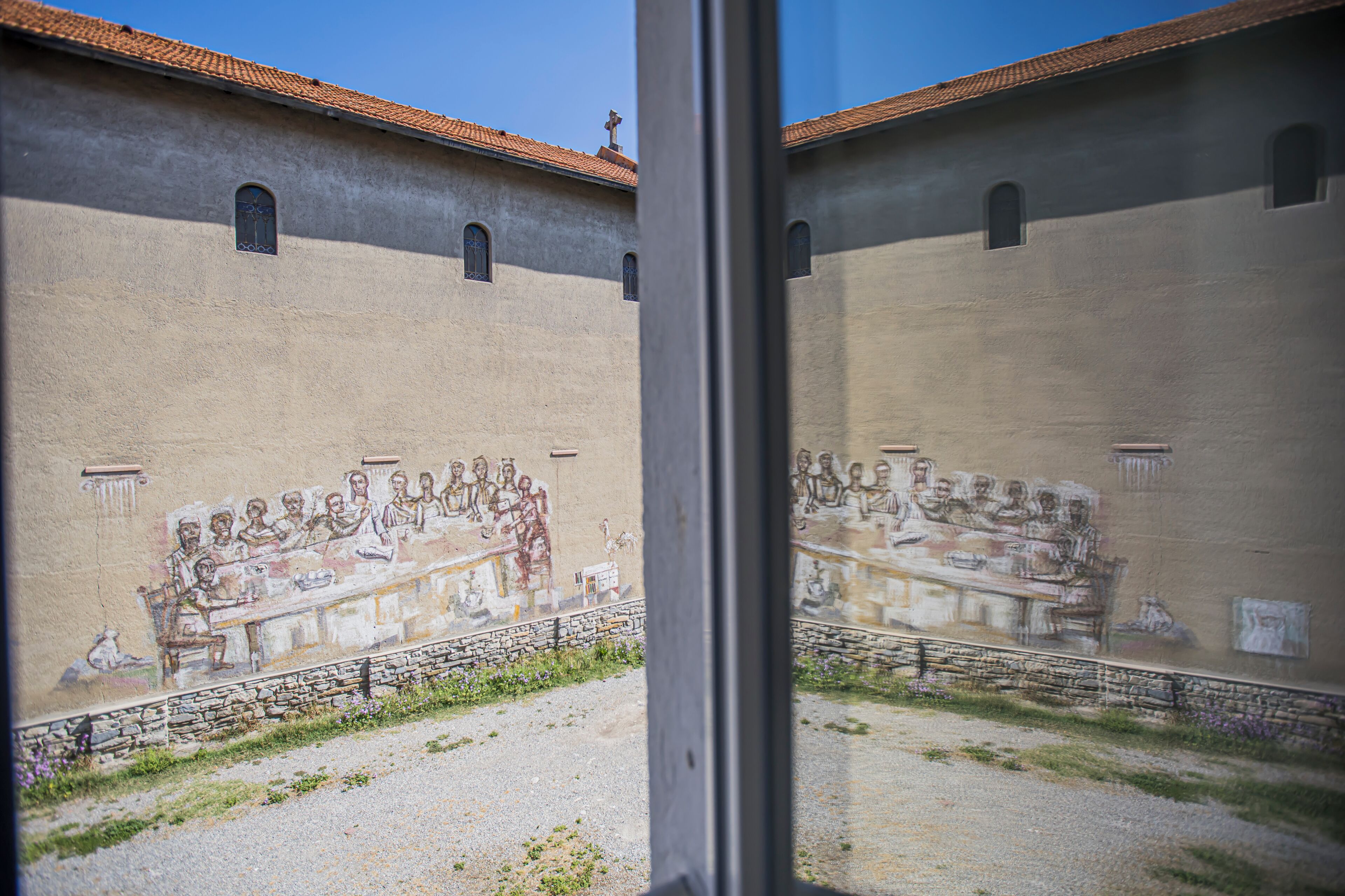 A mural of a historical scene on a building's exterior wall.