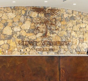 A stone wall with a logo and text, and a wooden counter below. - Villas between Provence and nature on the Château Roubine estate (Lorgues)