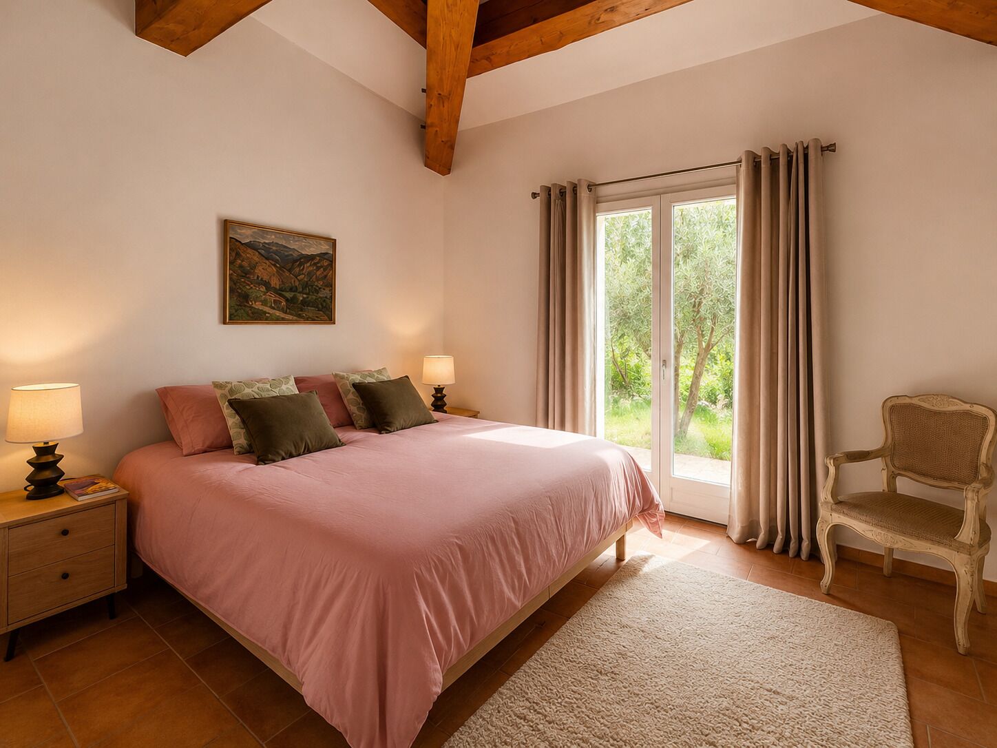 Un dormitorio con cama, dos lámparas de noche, una silla, una ventana con cortinas y un cuadro en la pared.