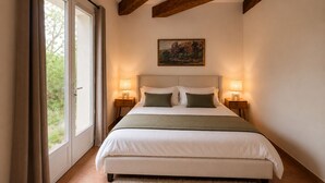 Un dormitorio con una cama grande, dos mesitas de noche, un cuadro en la pared y vistas al exterior.