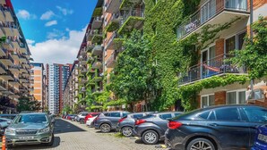 A row of parked cars along a paved street in a residential area with multi-story buildings, some with balconies and greenery. - HB apartments Politkovskaia (Tbilisi)