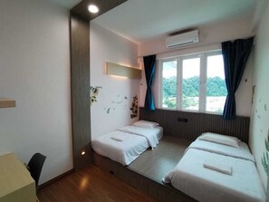 A room with two beds, a desk, and a window with curtains. - Trival Double 9 Homestay @ Sri Indah Sandakan (Sandakan)