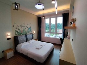 A bedroom with a bed, bedside tables, a nightstand, a window with curtains, and a view of greenery outside. - Trival Double 9 Homestay @ Sri Indah Sandakan (Sandakan)