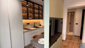Une cuisine moderne dotée d’appareils électroménagers intégrés, de meubles de rangement en bois et d’un coin repas avec une table et des chaises.
