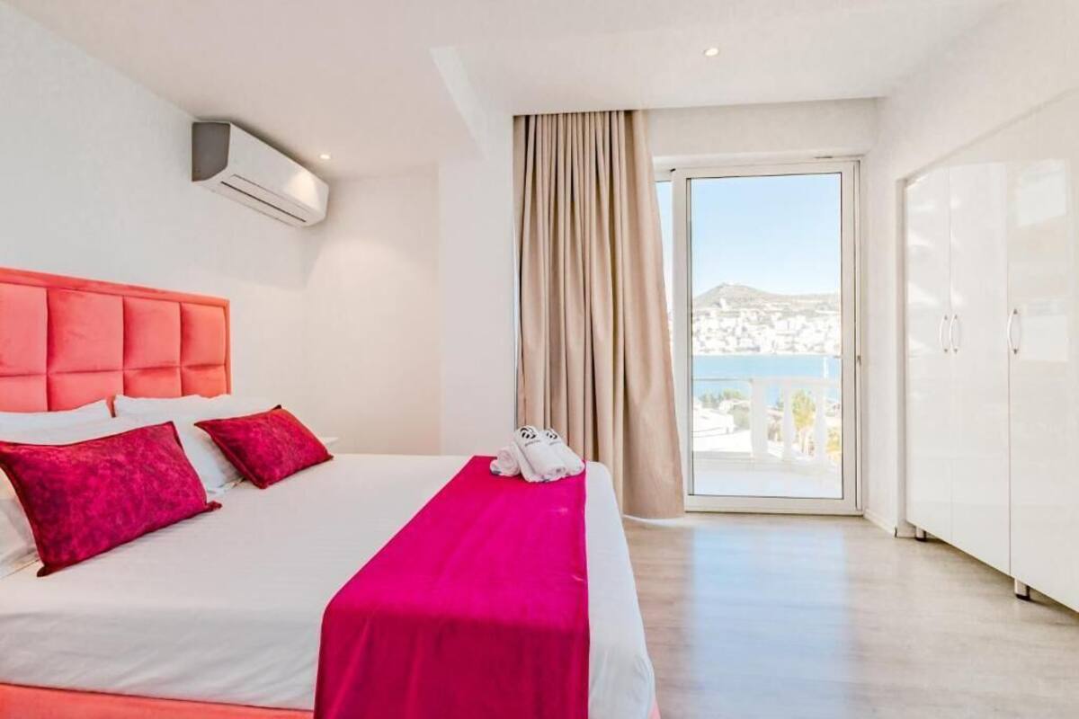 A hotel room with a bed, a window with a view, and a wardrobe.