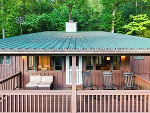 A rustic cabin with a porch, outdoor seating, and a metal roof. - 2BR Deep Creek Cabin | Game Room & Sunset Views (Bryson City)