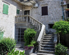 A stone building with a staircase leading to a balcony. - Charming Studio with Stunning Bay Views & Adriatic Soul⁠ (Kriva ulica)