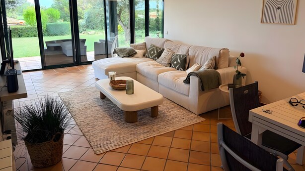 A modern living room with a sofa, coffee table, and a dining area with a table and chairs. - Villa 'Isabelle' with Shared Pool, Private Terrace and Wi-Fi (Navata)