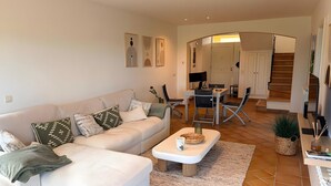 A living room with a sofa, coffee table, and a dining area with chairs and a table. - Villa 'Isabelle' with Shared Pool, Private Terrace and Wi-Fi (Navata)