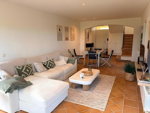 Ein Wohnzimmer mit einer Couch, einem Couchtisch und einem Essbereich mit Stühlen und einem Tisch.