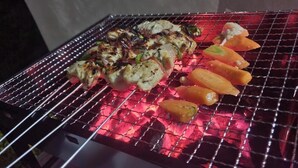 Ein Grill mit Fleisch- und Gemüsespießen.