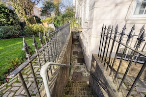 A narrow outdoor staircase with a metal railing, leading to a building entrance. - Stylish 2BR Georgian Flat • Prime Camden Location (London)