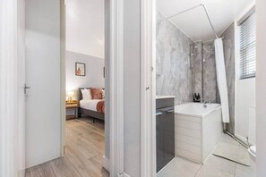 Une salle de bain moderne équipée d’une douche, d’un lavabo et de toilettes.