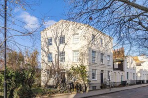 A multi-story building with a symmetrical facade, large windows, and a visible entrance. - Stylish 2BR Georgian Flat • Prime Camden Location (London)