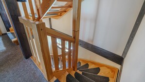 Eine Holztreppe mit Geländer und Teppichstufen.