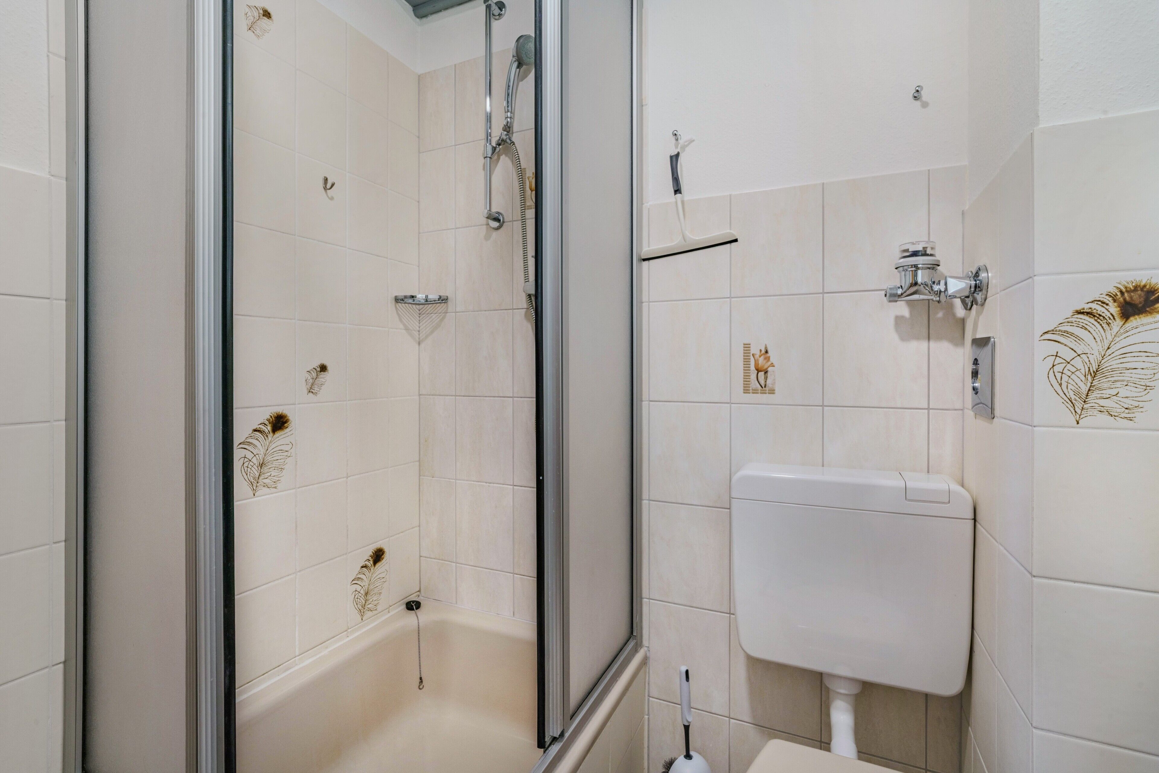 Ein Badezimmer mit Duschkabine, Toilette und Waschbecken.