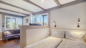Ein Schlafzimmer mit einem Bett, einer Couch und einem Fenster mit Blick.
