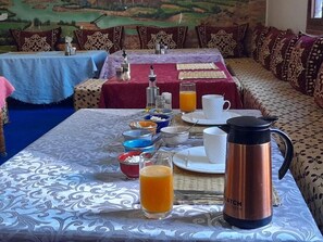Ein Frühstückstisch mit Kaffeemaschine und Orangensaft.
