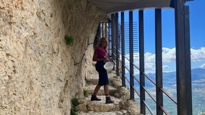 A person walking on a stone staircase with a metal railing, overlooking a mountainous landscape. - Charming town house located in the beautiful historic village of Casalanguida. (Casalanguida)