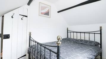 Ein Schlafzimmer mit einem Bett, einer Tür und einem Bild an der Wand.