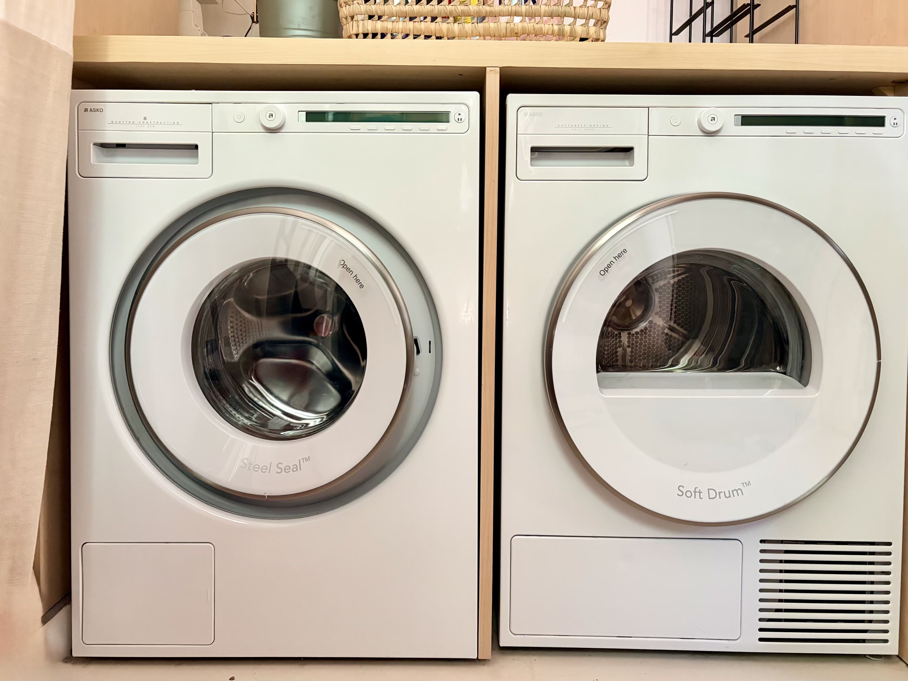 Twee ASKO wasmachines met voorlader naast elkaar.