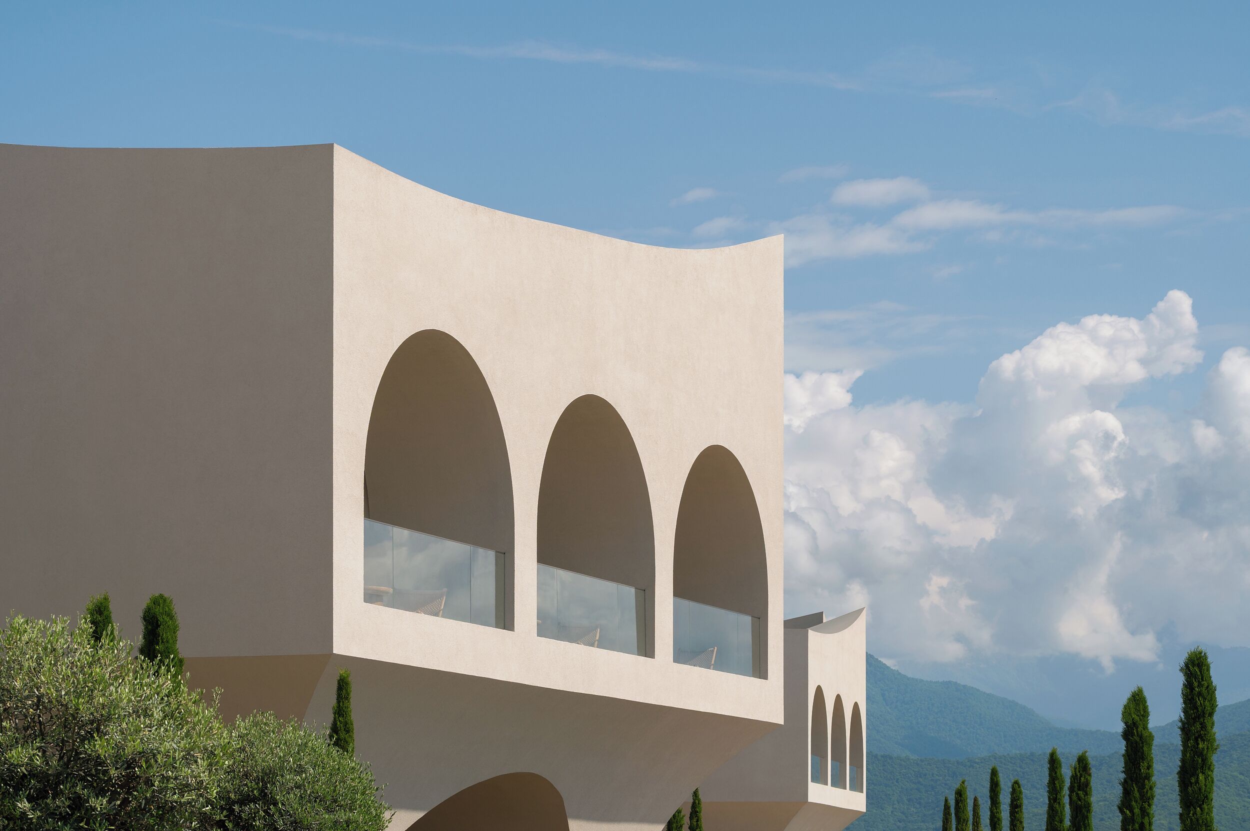 A modern building with three arched windows and a flat facade.