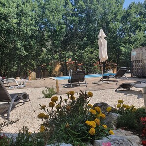 A poolside area with lounge chairs, a covered umbrella, and a small garden with flowers. -  3-bedroom house & private pool free parking/wifi, nestled between Rabac & Labin (Ripenda Kras)